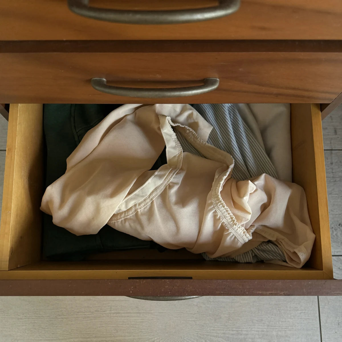 Une paire de bas de contention beige abandonnée dans un tiroir.