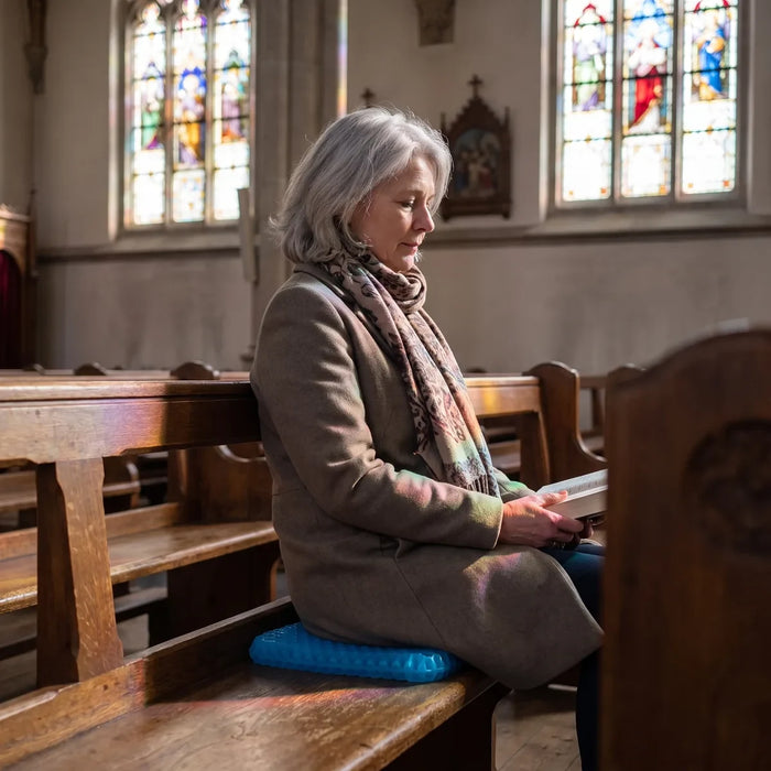 Femme assise sur un banc d eglise avec son coussin en gel