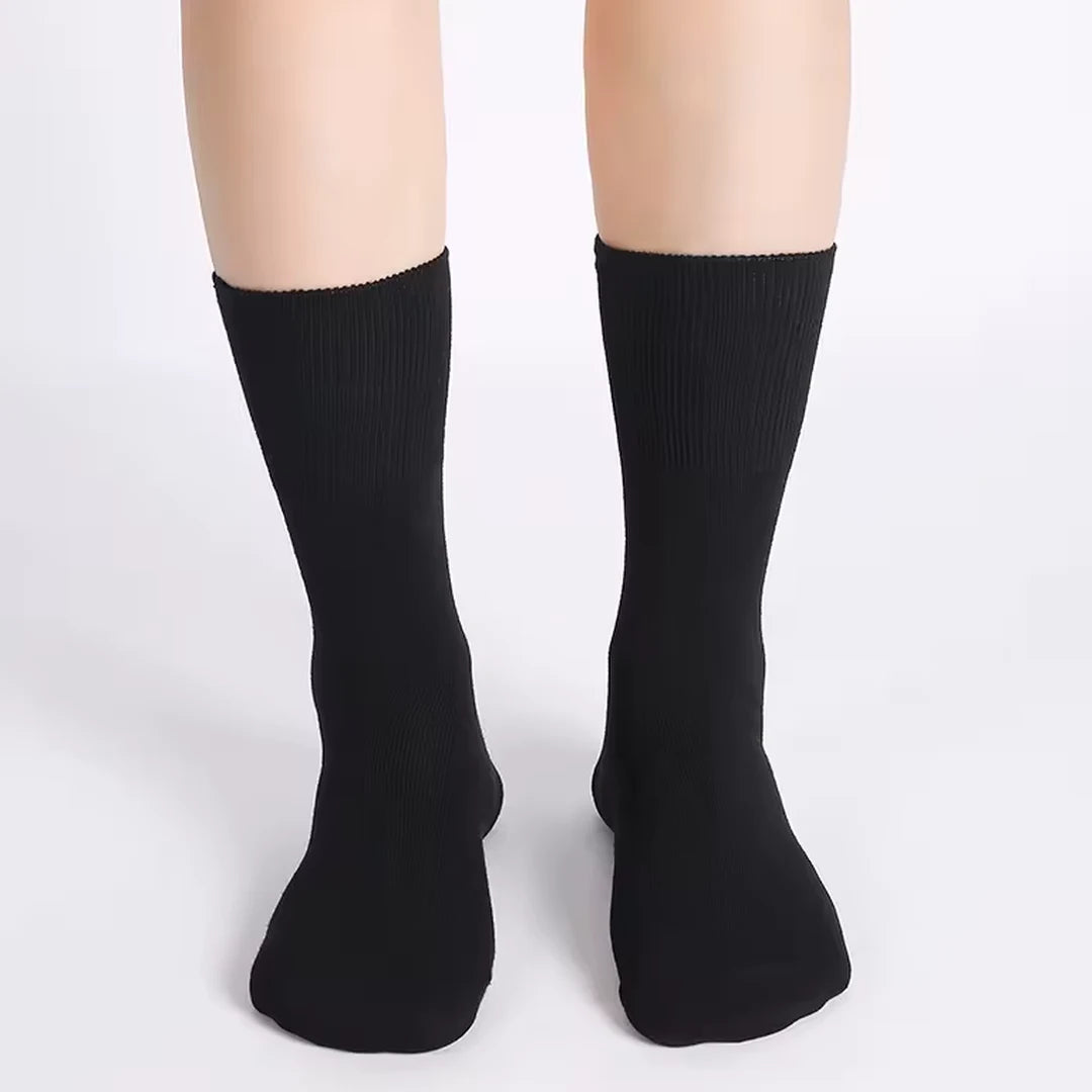 Deux pieds portant des chaussettes noires sans élastique.